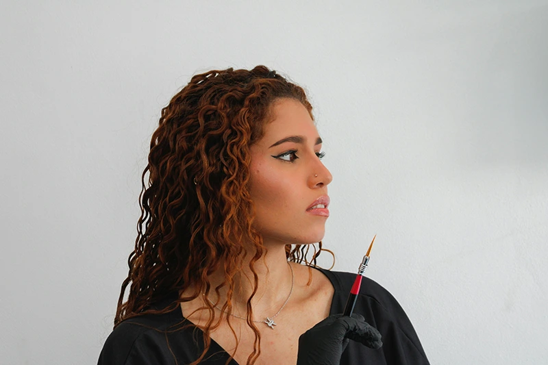 Woman in profile holding makeup brush - Regional Navigator Program - TurnAround