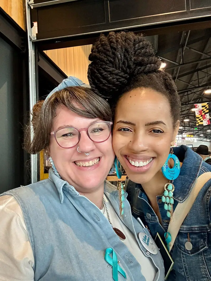 Two smiling women at event with teal ribbon - Advocacy and Resources - TurnAround